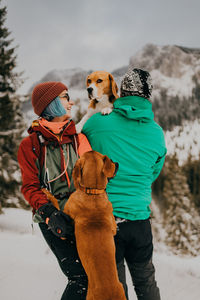 Couple in love and dogs playing in the snow