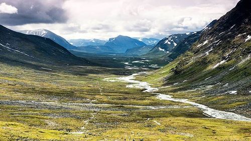 Scenic view of mountains against cloudy sky