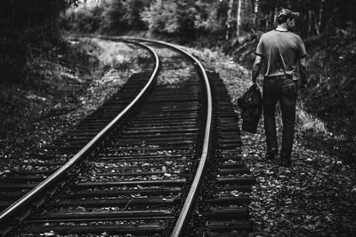 Rear view of man standing on railroad track