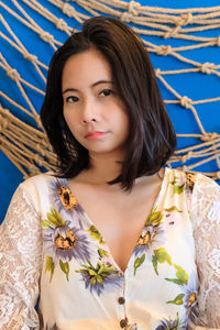 Portrait of beautiful young woman standing against wall