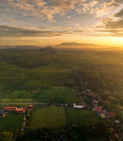 Scenic view of agricultural field against sky during sunset