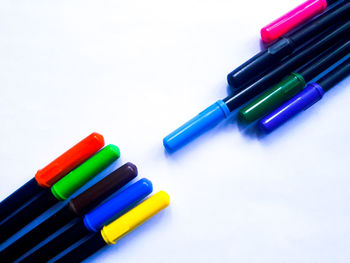 Close-up of colored pencils over white background