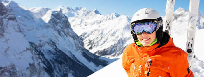 Portrait of smiling woman skiing on snowcapped mountain