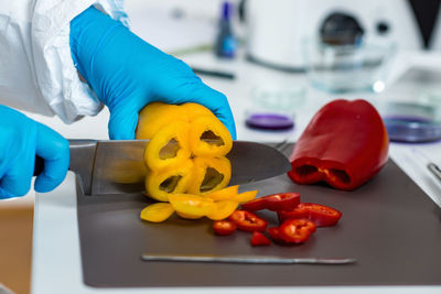 Cropped hands of scientist experimenting on bell peppers