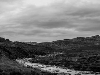 River stream on landscape against cloudy sky