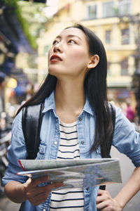 Mid adult woman looking away in city