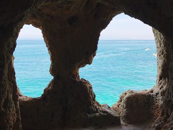 Scenic view of sea seen through cave