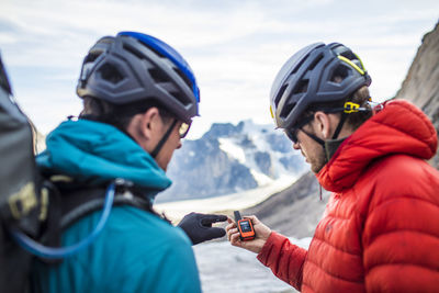 Two climbers use a gps to navigate mountain terrain.