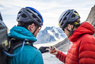 Rear view of man holding smart phone during winter