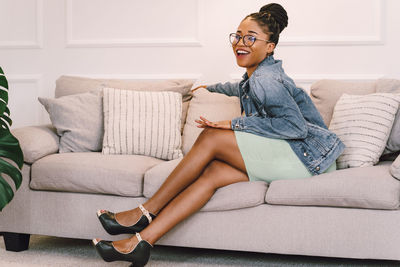 Young woman sitting on sofa at home