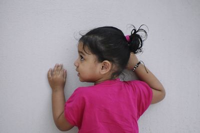 Cute girl against pink wall