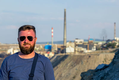 Portrait of young man wearing sunglasses against sky