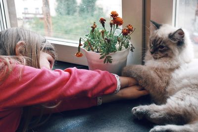 Close-up of girl with cat at home