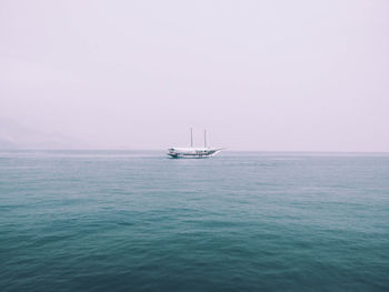 Ship sailing on sea against clear sky