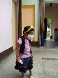 Full length of woman standing against wall
