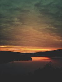 Scenic view of sea against dramatic sky during sunset