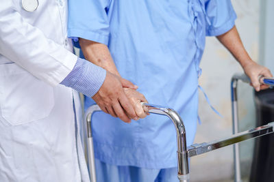 Midsection of doctor assisting patient at hospital