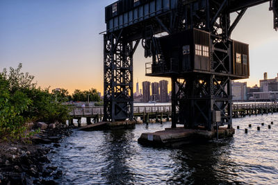 Bridge over river against sky during sunset