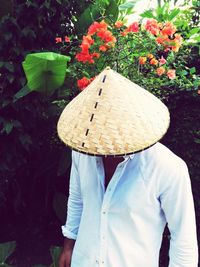 Midsection of person with umbrella standing by plants