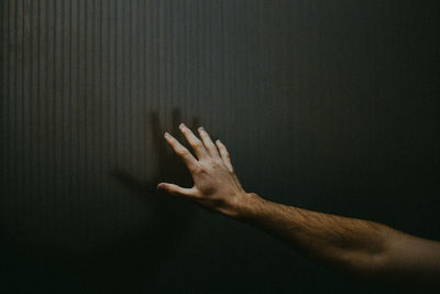 Close-up of cropped hand on wall