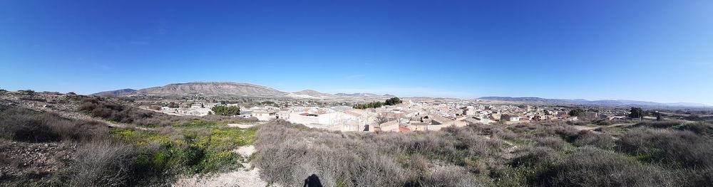 Panoramic view of landscape against clear blue sky
