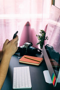 Midsection of person using mobile phone at table