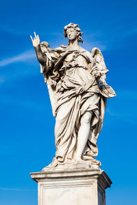 Low angle view of statue against blue sky