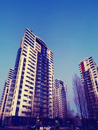 Low angle view of modern buildings against clear blue sky