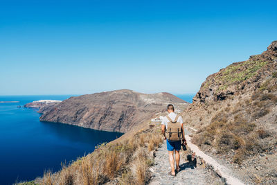 Full length of man on path against clear blue sky