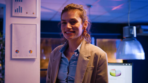 Portrait of young woman standing in office