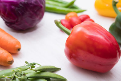 Close-up of red bell pepper with other vegetables on table