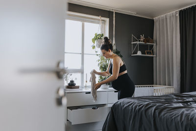 Pregnant woman organizing drawers and getting ready for baby arrival