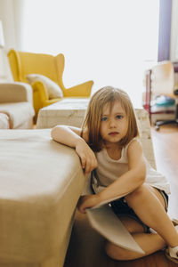 Portrait of young woman sitting on sofa at home