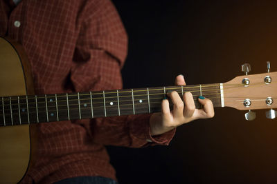 Midsection of woman playing guitar