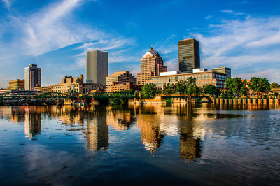 Reflection of buildings in river against sky