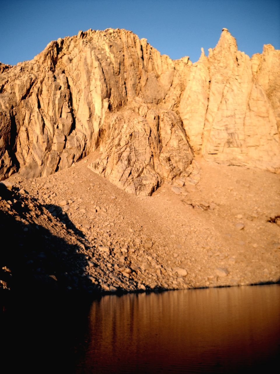 water, mountain, tranquil scene, tranquility, beauty in nature, scenics - nature, rock, sky, nature, rock - object, non-urban scene, no people, reflection, lake, rock formation, solid, mountain range, day, waterfront, outdoors, formation, climate, eroded, arid climate