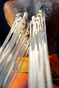 Close-up of hooks with rope pierced on man back