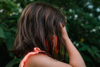 Little girl in orange mask covering her eyes