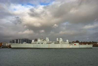 Sea by city buildings against sky