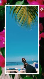 Woman swimming in pool at beach against sky