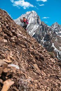 Hiker climbing in front of mount even-thomas in kananskis country