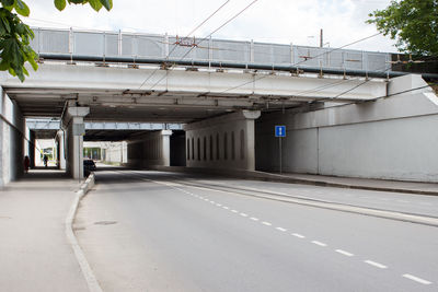 Empty road by buildings against sky