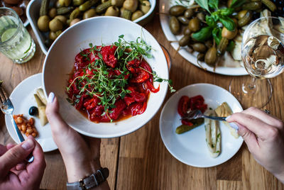 Cropped image of hands with food served on table