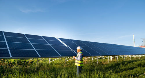 Solar engineer working with digital tablet at renewable energy farm