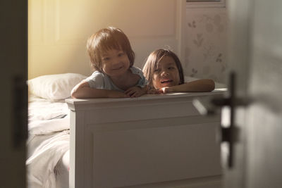 Portrait of mother and son on bed at home