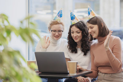 Friends using laptop at office