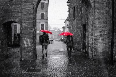 People walking on wet glass in city