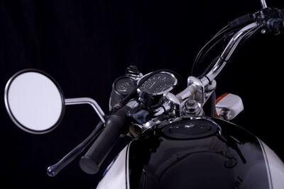 Close-up of motorcycle over black background