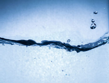 Close-up of water splashing against blue background