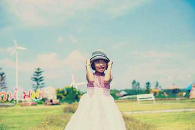 Woman wearing hat on field against sky